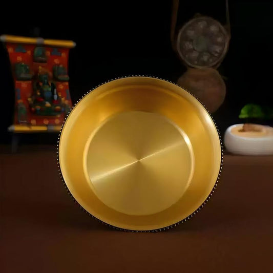 Tibetan Buddhist sacrificial implements culture: Close-up of an Ashtamangala brass chalice showcasing exquisite Buddhist sacrificial items art and hand-engraved details.