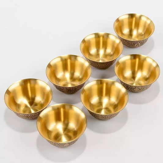 Tibetan Buddhist sacrificial implements culture: Close-up of hand-carved brass water cups showcasing exquisite Buddhist sacrificial items art and Himalayan craftsmanship.