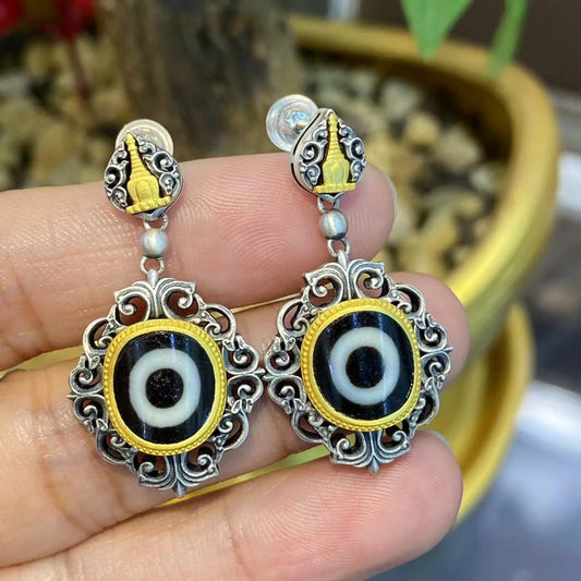 Handcrafted silver Yellow Jambhala and Green Tara Zhakiram earrings, inspired by Tibetan Buddhist jewelry culture, embodying spiritual protection and abundance.