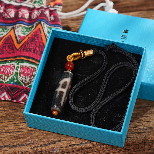 Handcrafted jewelry art necklace featuring a sacred Dzi amulet, representing fortune and wisdom in Tibetan traditions.