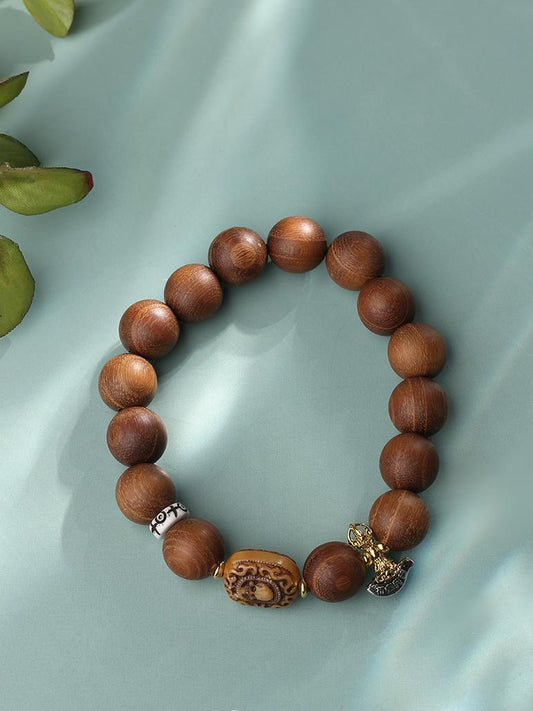 Detailed close-up of the Hand-Painted Sandalwood, Bone, and Silver Bracelet. Highlights the intricate, freehand-painted Tibetan motifs that blend seamlessly with the textures of sandalwood, bone, and silver, creating a unique piece of jewelry art.