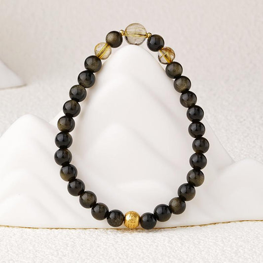 Moonlight Glow Golden Obsidian bracelet with Tibetan Buddhist jewelry art, featuring hand-painted moon-inspired designs for spiritual protection.