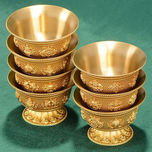 Tibetan Buddhist sacrificial implements culture: Close-up of handmade brass water cups showcasing authentic Buddhist sacrificial items art and traditional Himalayan craftsmanship.