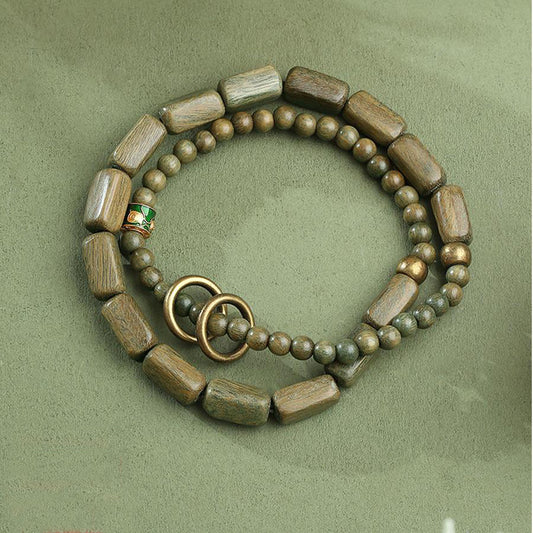 Gentle Wind Prayer bracelet in green sandalwood, showcasing Tibetan Buddhist jewelry art. Features hand-strung sandalwood beads with copper details, ideal for daily prayer and meditation.