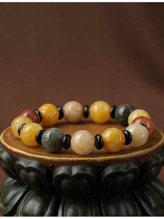 Golden Silk Jade prayer beads with obsidian spacers, handmade using traditional Tibetan Buddhist jewelry techniques. This sacred strand represents the rich culture of spiritual adornments.
