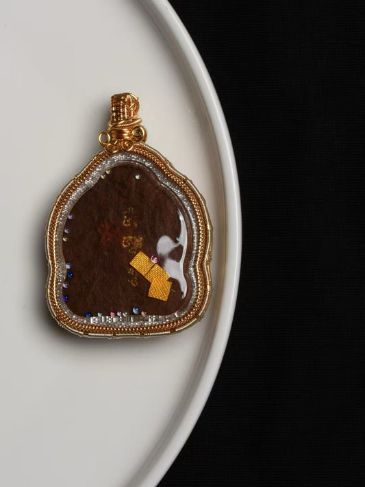 Hand-painted Yellow Jambhala thangka pendant inspired by Tibetan Buddhist jewelry culture, symbolizing wealth and prosperity.