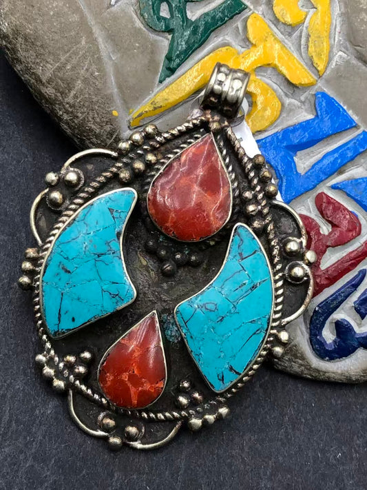 Handcrafted turquoise inlay pendant reflecting Tibetan Buddhist artistry. A vibrant, spiritual accessory symbolizing protection, balance, and spiritual connection.