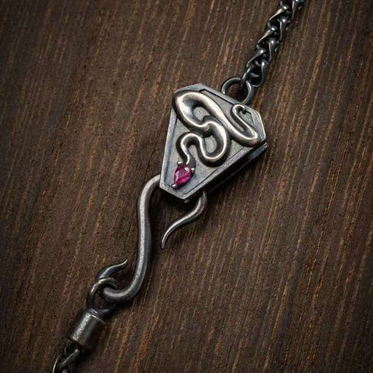 Hand-painted silver serpent bone pendant inspired by Tibetan Buddhist jewelry culture, symbolic jewelry art necklace.