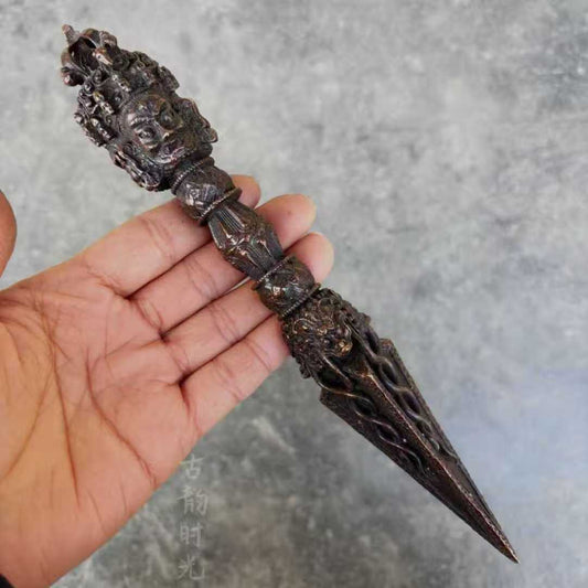 This Nepalese handcrafted Three-Faced Phurba with Vajra is made of brass, symbolizing spiritual protection and power. A sacred tool used in Tibetan Buddhist rituals for clearing obstacles and invoking positive energy.