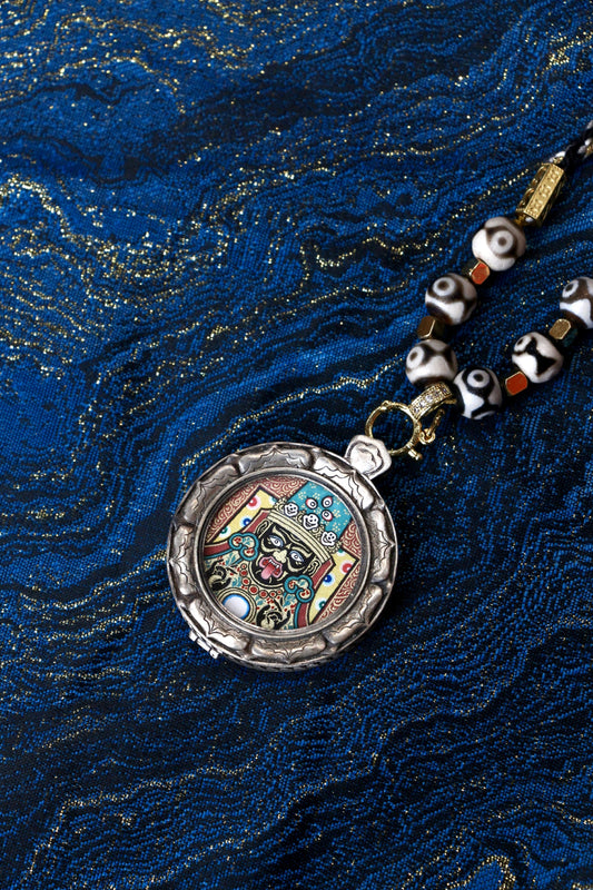 Macro view of the 2.5cm Zaki Lhamo Thangka core, showing the exquisite detail and natural mineral colors used by Regong master lamas.