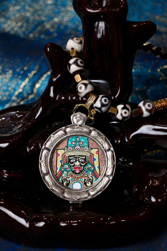 A sacred hand-painted Zaki Lhamo (Female Wealth Deity) Buddha Head Thangka pendant from Regong in an exclusive Three Rabbits silver case.