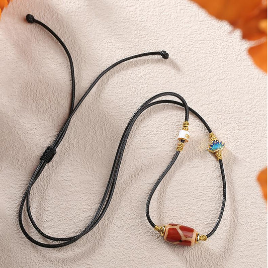 Handmade Tibetan Buddhist Qihongrou Tianzu pendant with red agate and copper lotus design.