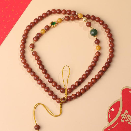 Handcrafted Tibetan Buddhist amber and agarwood necklace symbolizing harmony and universal balance.