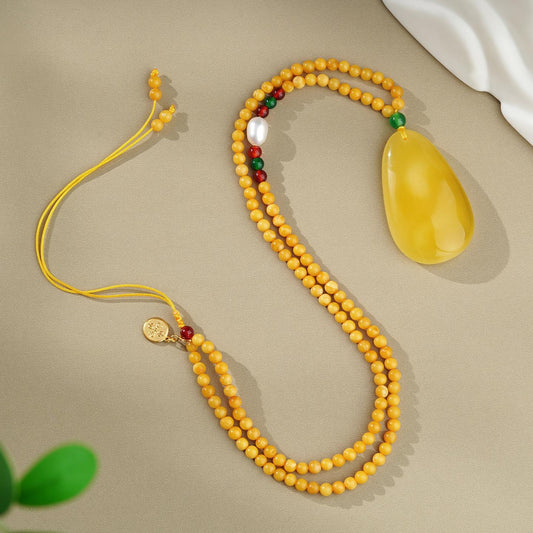 Handmade Tibetan Buddhist amber necklace with agate, pearl, and 925 silver, symbolizing purity and prosperity.