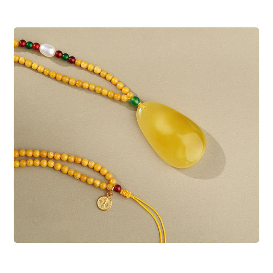 Cloud Honey amber necklace combining red and green agate, pearls, and silver craftsmanship for harmony and protection.