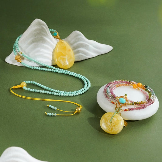 Tibetan Buddhist handcrafted amber pendant with silver, turquoise, and tourmaline, symbolizing harmony and spiritual radiance.