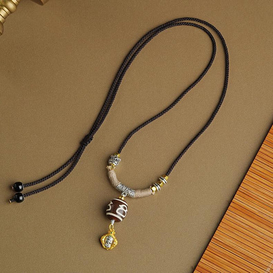 Authentic Tibetan Buddhist Dzi Bead Pendant made from genuine agate with a detailed copper setting.