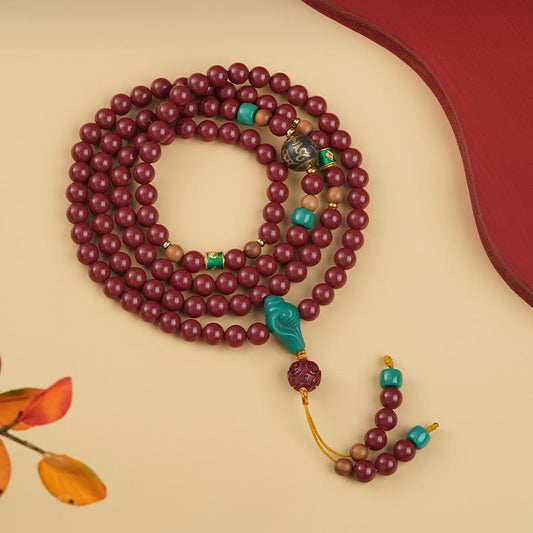 Handcrafted Tibetan-Buddhist prayer beads made from cinnabar, sandalwood, glass, and copper, featuring mantra ash bead details
