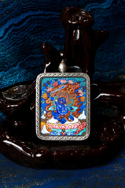 A sacred hand-painted Acala (Fudo Myoo) Thangka pendant from Regong, featuring the wrathful Wisdom King in a fine silver frame.