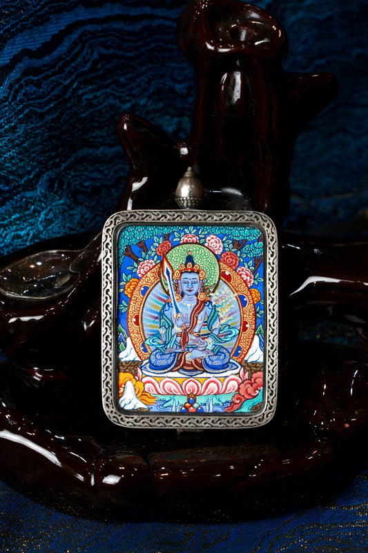 A sacred hand-painted Akasagarbha Bodhisattva Thangka pendant from Regong, featuring the Bodhisattva of Boundless Space in a fine silver frame.