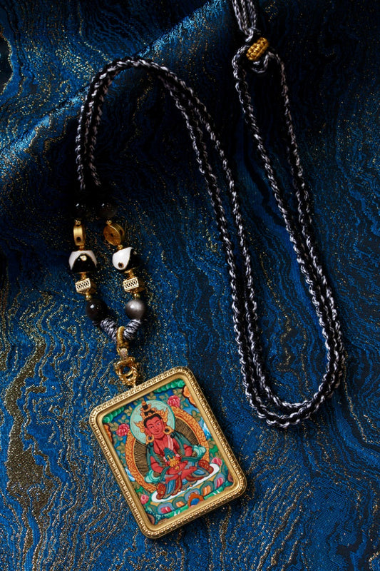 Medicine Buddha thangka pendant depicting the Tibetan Buddhist deity of healing and longevity, symbolizing health and inner balance.