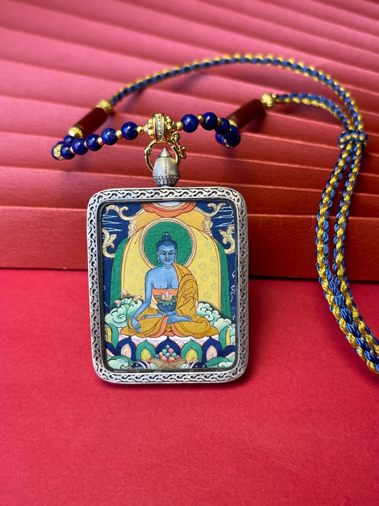 Hand-painted Bhaisajyaguru (药师佛) Thangka pendant 3.5x4.5cm with silver casing featuring the medicine bowl and haritaki, representing the power to eliminate disease and disaster in Buddhist tradition.