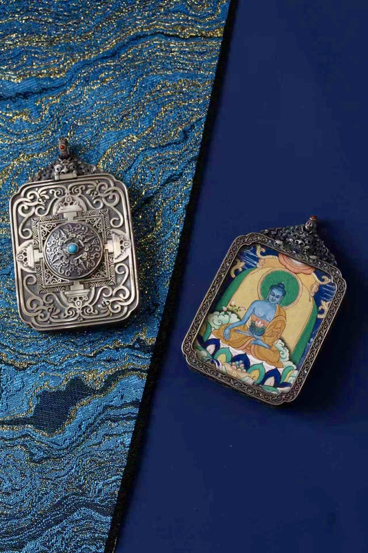 Medicine Buddha thangka pendant depicting the Tibetan Buddhist deity of healing, health, and spiritual balance.