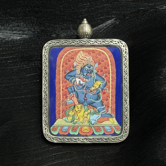 The Chigung Black Jambhala Thangka pendant displayed as a sacred amulet for wealth and immediate blessings, embodying the wealth deity in Tibetan Buddhist tradition.