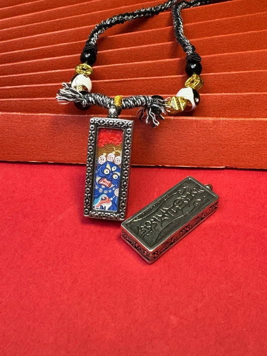 Hand-painted Rekong Black Jambhala (黑财神) Thangka pendant 1x3 inch with copper casing featuring the king of wealth deities, representing instant bestowal of wealth in Buddhist tradition.