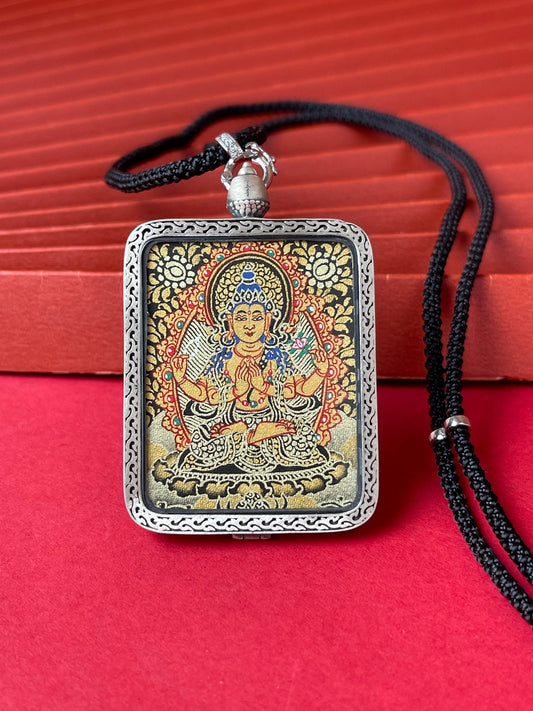The Rekong Black Gold Four-Armed Avalokiteshvara Thangka pendant with deer relief silver casing displayed as a sacred amulet for compassion and family harmony, embodying Buddhist tradition.