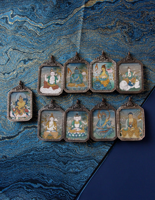 Tibetan Buddhist thangka pendant depicting Four-Armed Avalokiteshvara, symbolizing compassion, mercy, and protection.