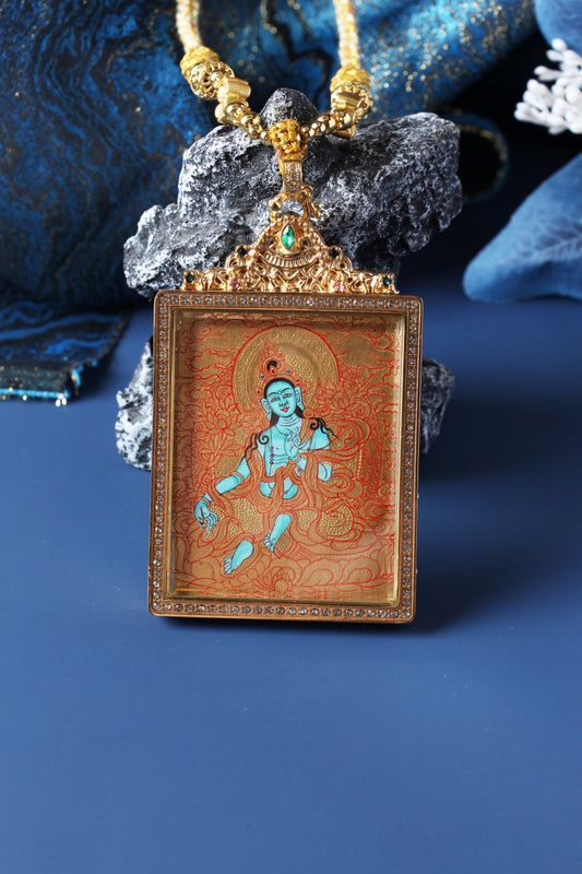 A 3.5x4.5cm hand-painted Tibetan Buddhist Green Tara Thangka pendant featuring the goddess of compassion and swift action, encased in exclusive 925 Sterling Silver, representing protection and liberation in Tibetan Buddhist culture.