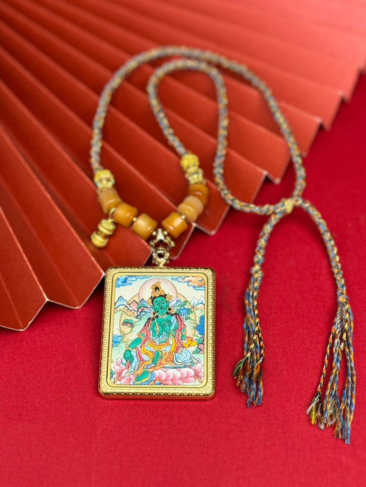 Hand-painted Nepal Green Tara (绿度母) Thangka pendant 4x5cm with titanium casing featuring the chief of twenty-one Taras, representing relief from suffering and fulfilment of wishes in Buddhist tradition.