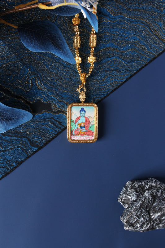 Close-up detail of the Tibetan Buddhist Medicine Buddha Thangka painting showing intricate natural mineral pigment work and gold-accented robes, showcasing the masterful artistry of Tibetan lineage painters.