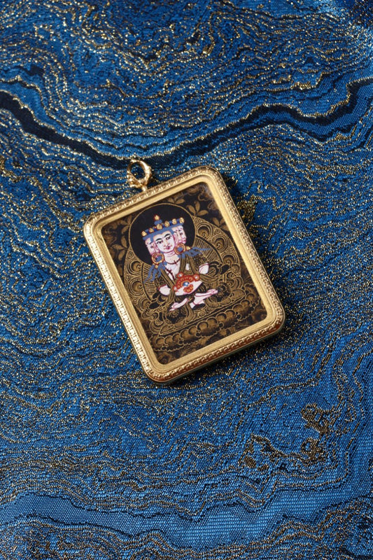 Mahavairocana thangka pendant representing the cosmic Buddha and the embodiment of universal wisdom in Tibetan Buddhism.