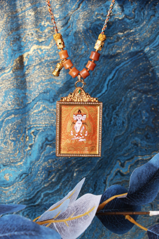 The Rebgong Vairocana Buddha Thangka pendant displayed as a sacred amulet for wisdom and success, embodying the cosmic light of Tibetan Buddhist tradition.