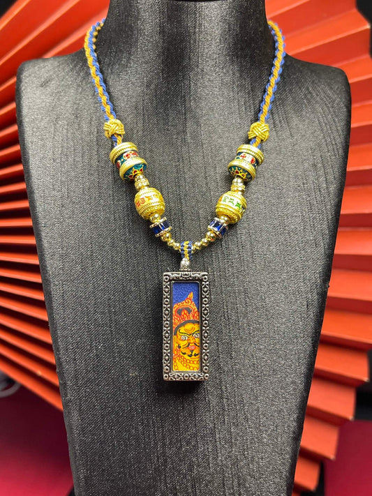 Close-up detail of the Nepal Blue Base Yellow Jambhala Thangka showing hand-painted mineral pigments, showcasing the masterful artistry.