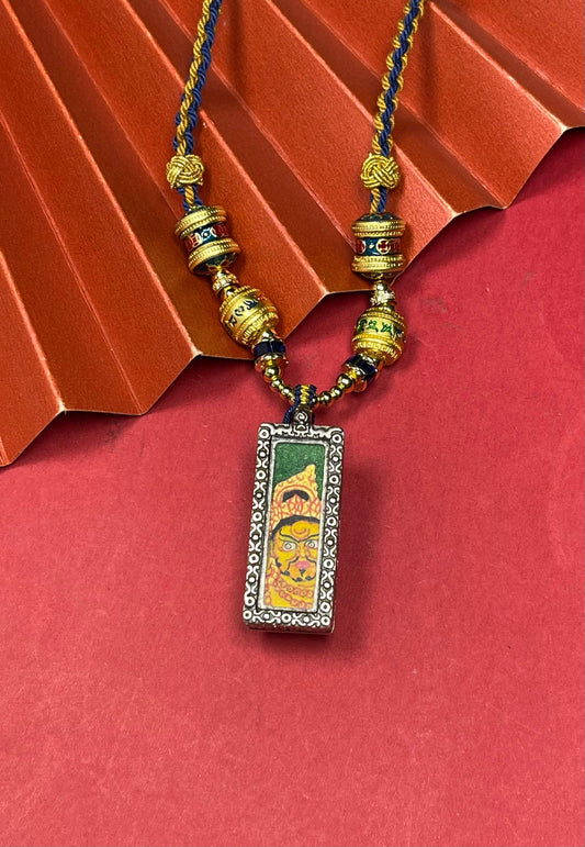 Hand-painted Nepal Green Base Bold Yellow Jambhala (绿底粗矿黄财神) Thangka pendant 1x3 inch with silver copper casing featuring the chief of wealth deities, representing prosperity in Buddhist tradition.