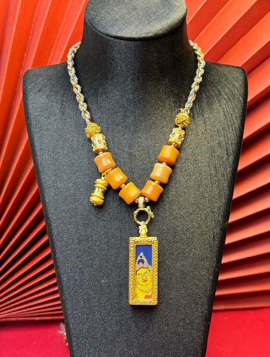 Close-up detail of the Rekong Yellow Jambhala Thangka showing hand-painted mineral pigments and lapis, showcasing the masterful artistry and rich texture.