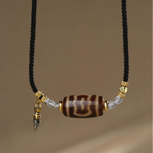 Handmade Tibetan Buddhist Garuda Dzi agate necklace symbolizing protection and power.