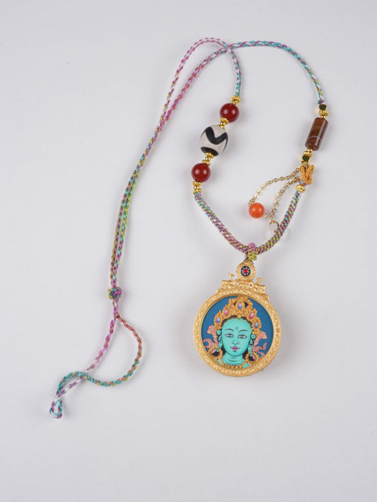 Mini Tibetan Thangka painting pendant of Green Tara, crafted on canvas with mineral pigments.