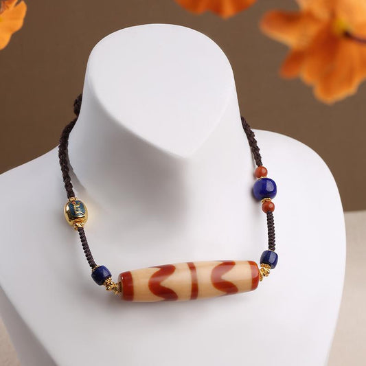 Tibetan handcrafted red carnelian agate tooth bead amulet pendant, inspired by Buddhist jewelry art.