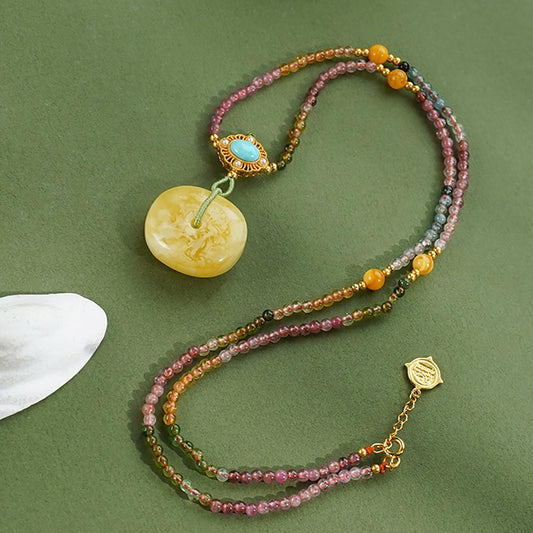 Spiritual Tibetan pendant made from amber, turquoise, and tourmaline — a symbol of blessings and joy.