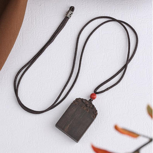 Kyara agarwood pendant with cinnabar Potala Palace bead symbolizing purity.