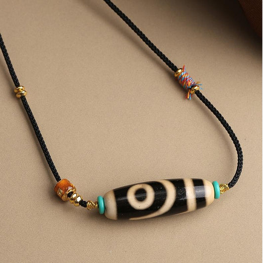 Tibetan Buddhist Two Eyes Dzi pendant made of agate and symbolic glass bead