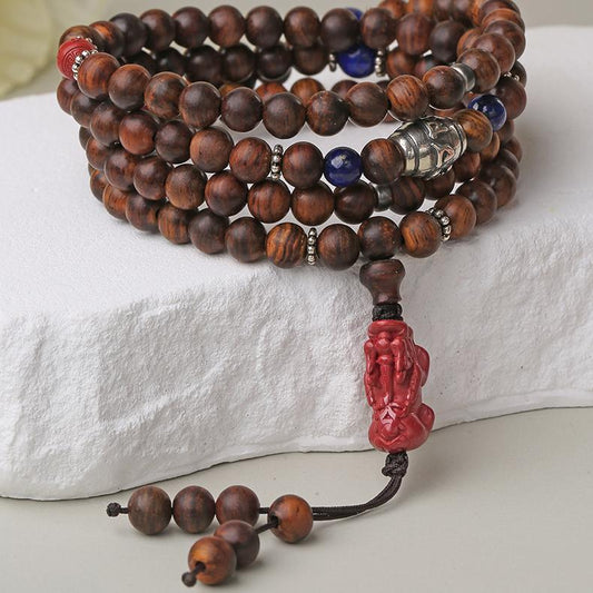 Handcrafted Tibetan Buddhist prayer beads featuring cinnabar Pixiu carving, Huanghuali wood, and silver details