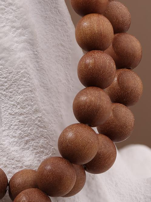 Pure hand-carved sandalwood mala bracelet symbolizing peace and spiritual protection.