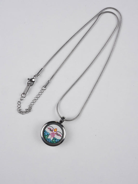 Close-up of Four-Armed Avalokiteshvara Thangka pendant, 2 cm round miniature, traditional Tibetan craftsmanship