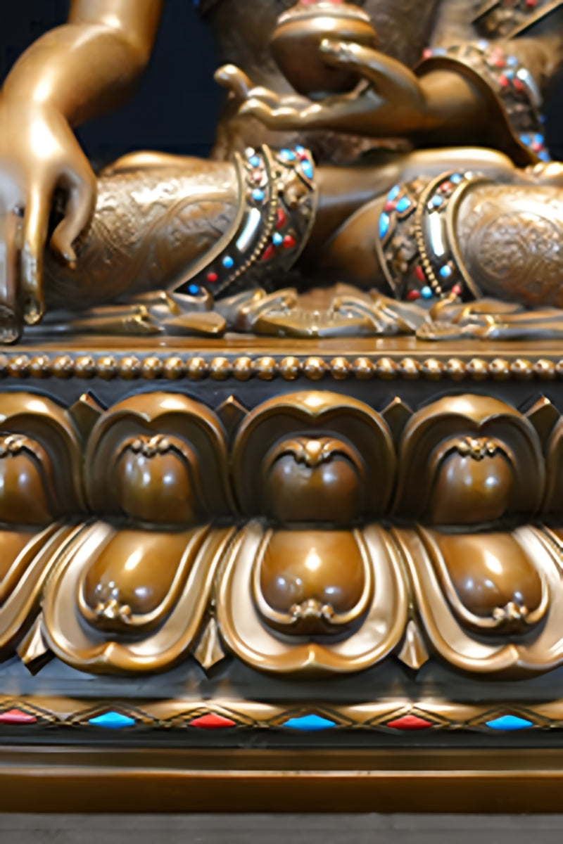 Shakyamuni Buddha figure in brass, hand-painted with vibrant mineral colors, reflecting Tibetan Buddhist art.