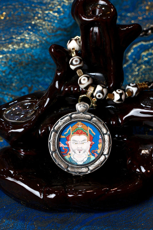 A sacred hand-painted Padmasambhava (Guru Rinpoche) Buddha Head Thangka pendant from Tibet in an exclusive Three Rabbits silver case.